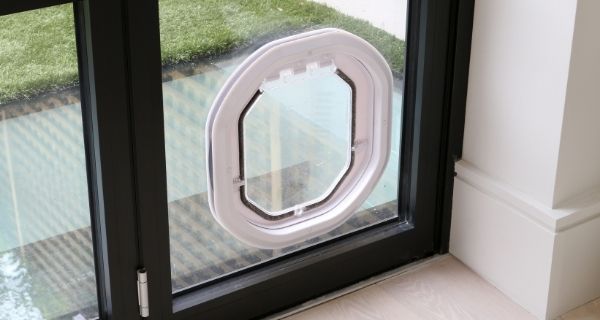 cat flap incorporated into steel look bifold doors with black frames
