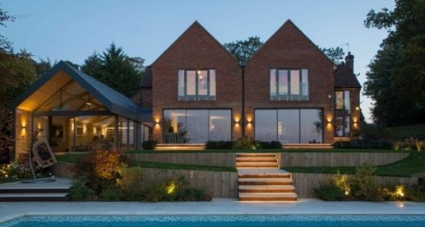 contemporary home with symetrical peaked towers and the read and a juliet balcony with french doors on both