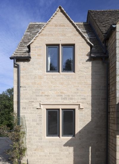 grey framed tilt and turn windows on a traditional architecture style home