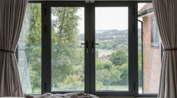 three pane black bifold door with tall fixed casement windows