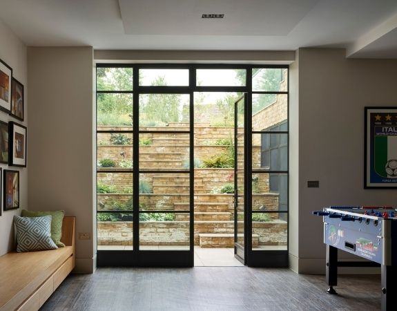 steel patio doors designed as a casement door with sidelights and dark steel framed glazing