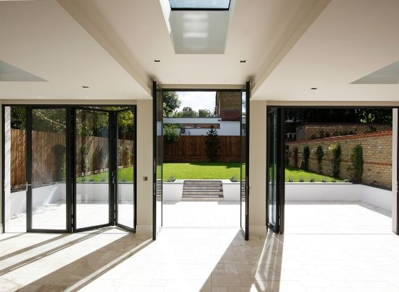 contemporary home extension with a tall casement door and slim bifolding patio doors either side