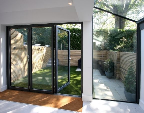 three pane aluminium bifold door and up and over structural glazing eaves window and roof glazing