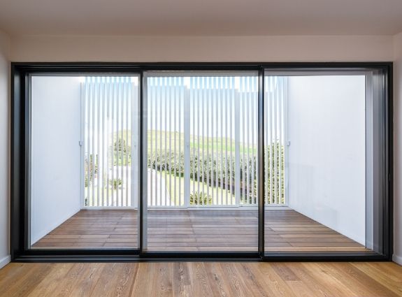 three pane slim sliding door with minimal aluminium framing and flush thresholds