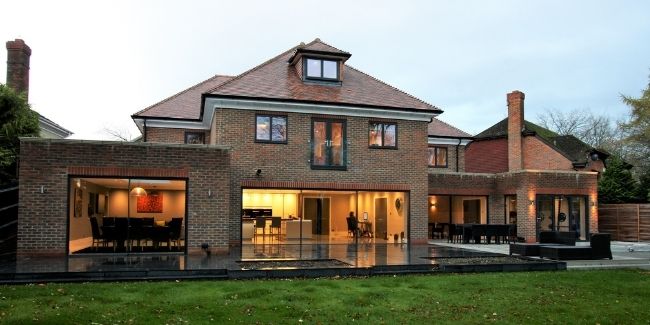traditional English style home with red brickwork and a juliet balcony and peaked roofs
