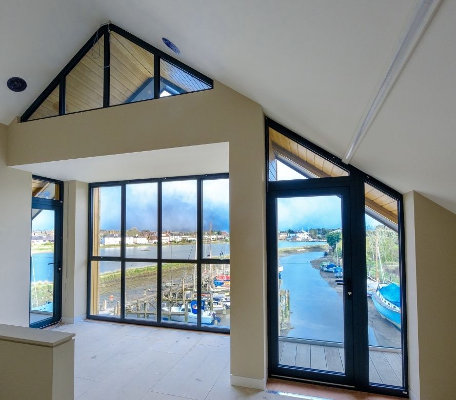 gable end windows and an aluminium casement door leading to and external balcony protected by a frameless glass balustrade