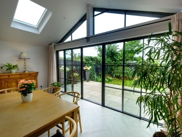 biparting sliding glass patio door with glazing bars and gable end window used to allow in a vast amount of natural light to this home
