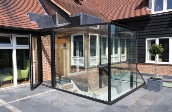 small glass box extension created using Invisio structural glazing and an aluminium casement door