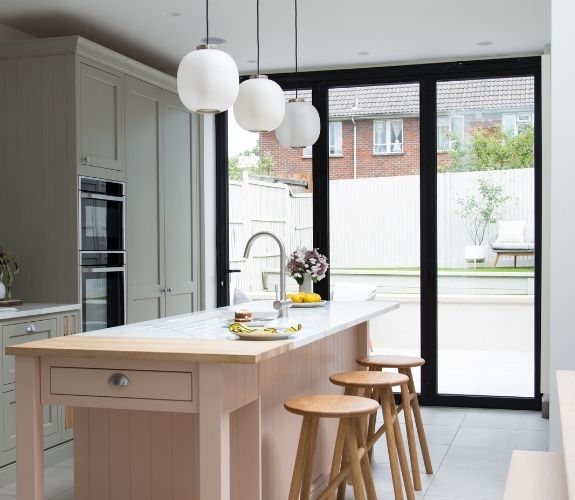 three pane aluminium bifold patio door that allow natural light into this modern kitchen extension