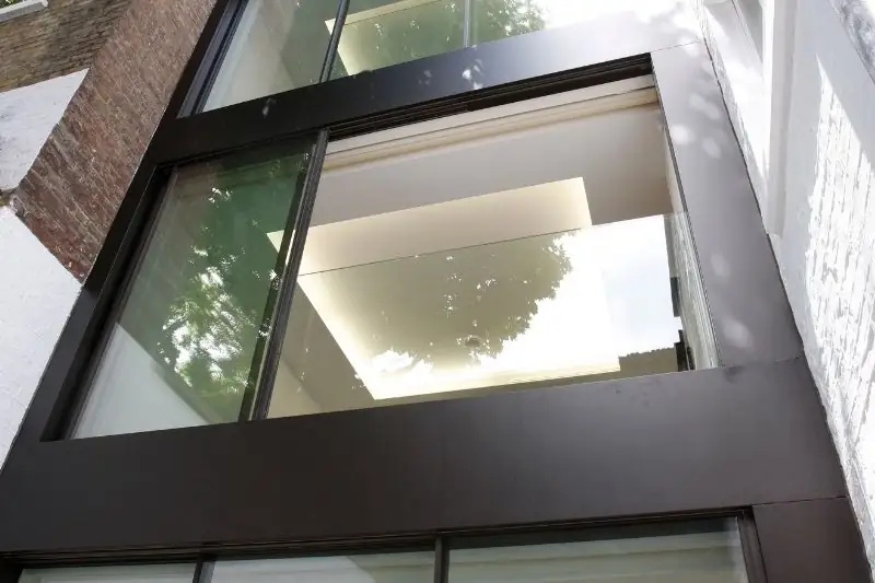 contemporary Juliet balcony design with a frameless glass balustrade and slim sliding door