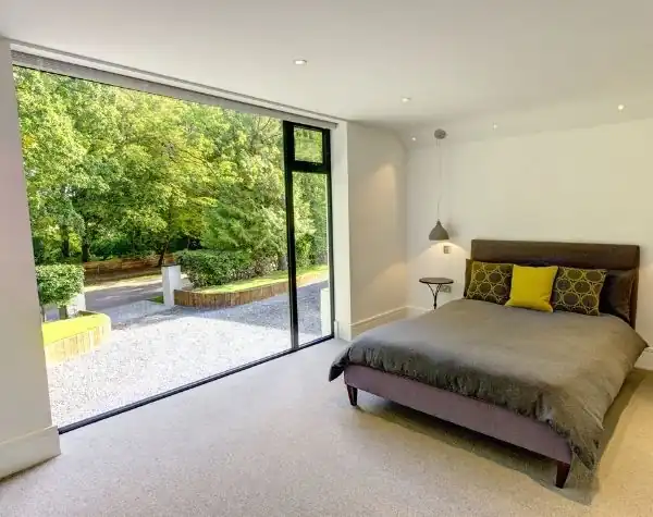 large fixed casement window in the bedroom of a new build home with solar control glass to control solar gain
