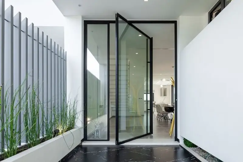 large glass pivot door with slim aluminium framing