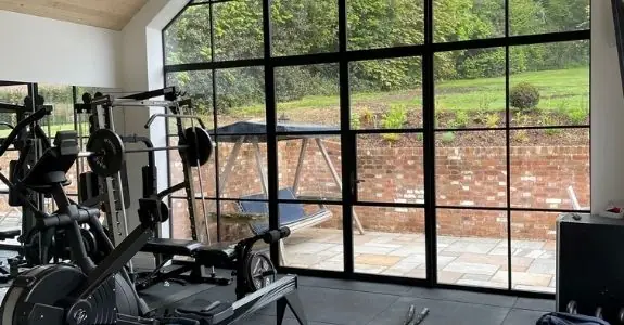 home gym with a double sieger legacy casement door surrounded by a fixed glass façade with glazing bars