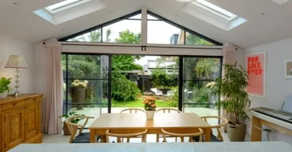 open plan living space with biparting sliding patio doors and gable end windows with glazing bars for a steel look design