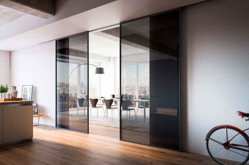 internal glass pivot door an fixed glazing used to create a broken plan living space in a family home